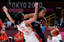 France's Iliana Rupert (12) drives around Spain's Cristina Ouvina (5) during a women's basketba ...