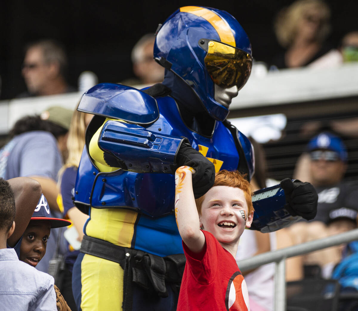 Colton Bunnell, 8, flexes with the help of Las Vegas mascot Aviator during a minor league baseb ...