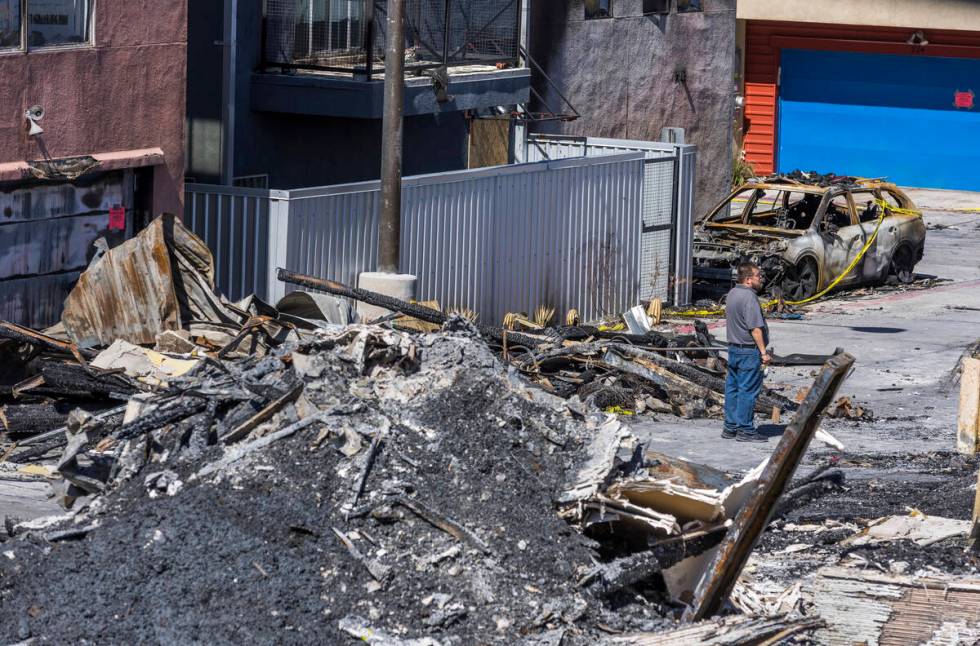 A man looks to the damage within the Urban Lofts Townhomes property where fire originated from ...