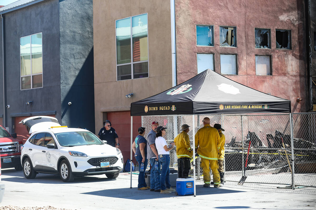 Investigators work the scene of the massive fire that torched 10 buildings and dozens of cars o ...