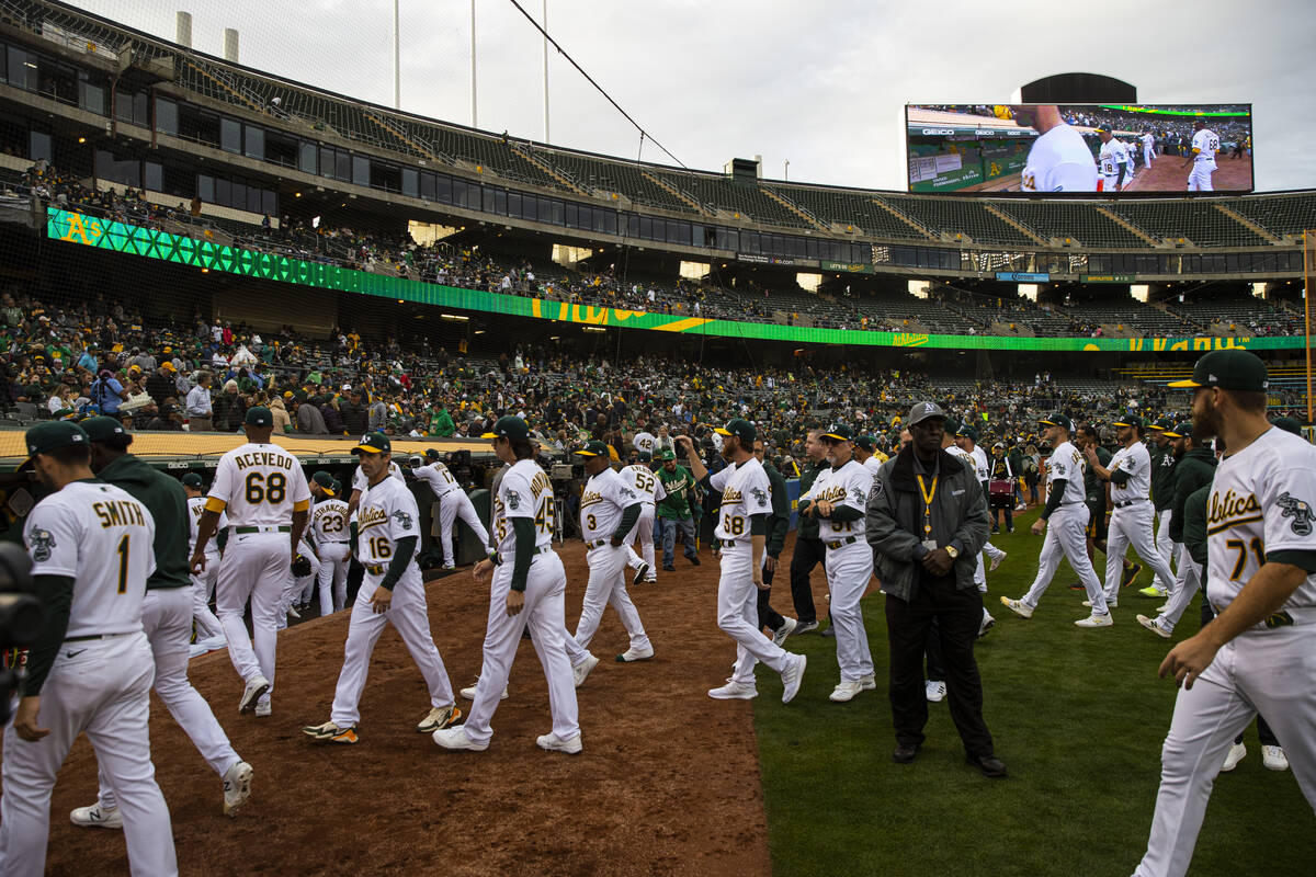 Oakland Athletics players head to the dugout before the start of the opening night game against ...