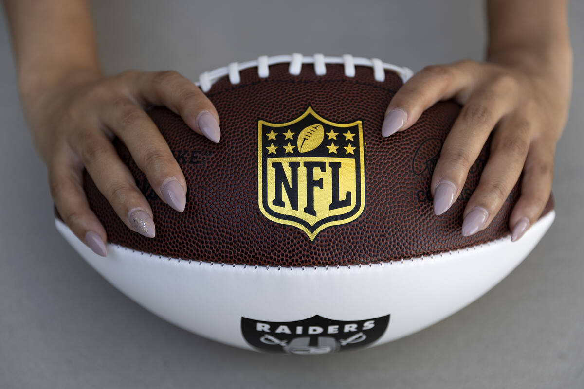 Nicole Adams holds a Raiders-themed football at her home on Friday, June 3, 2022. Adams worked ...