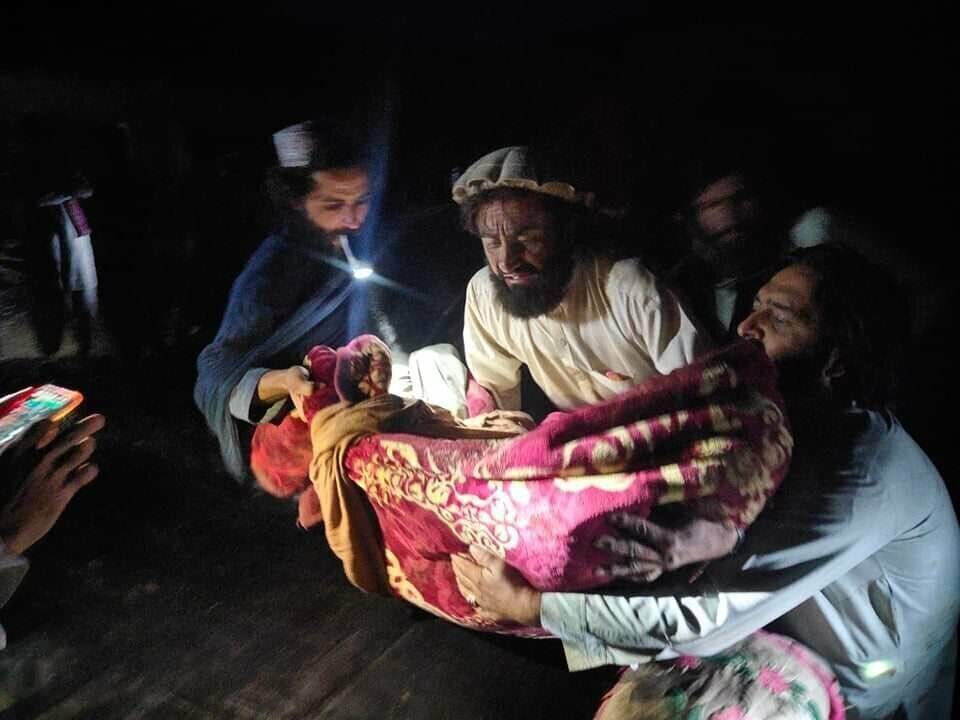 In this photo released by a state-run news agency Bakhtar, Afghans evacuate wounded in an earth ...