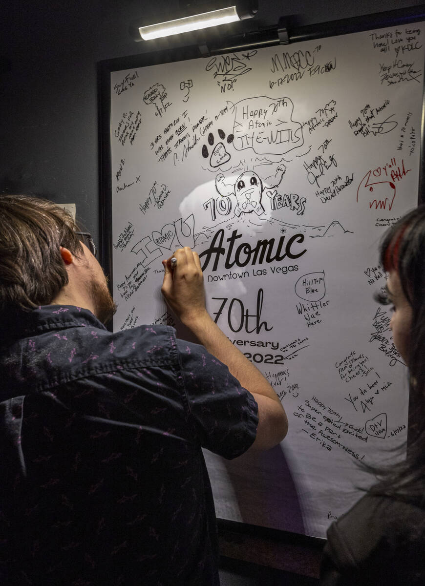 Patrons Jaz Kelso and Gina Willocks sign the guest board during the start of the Atomic Liquors ...