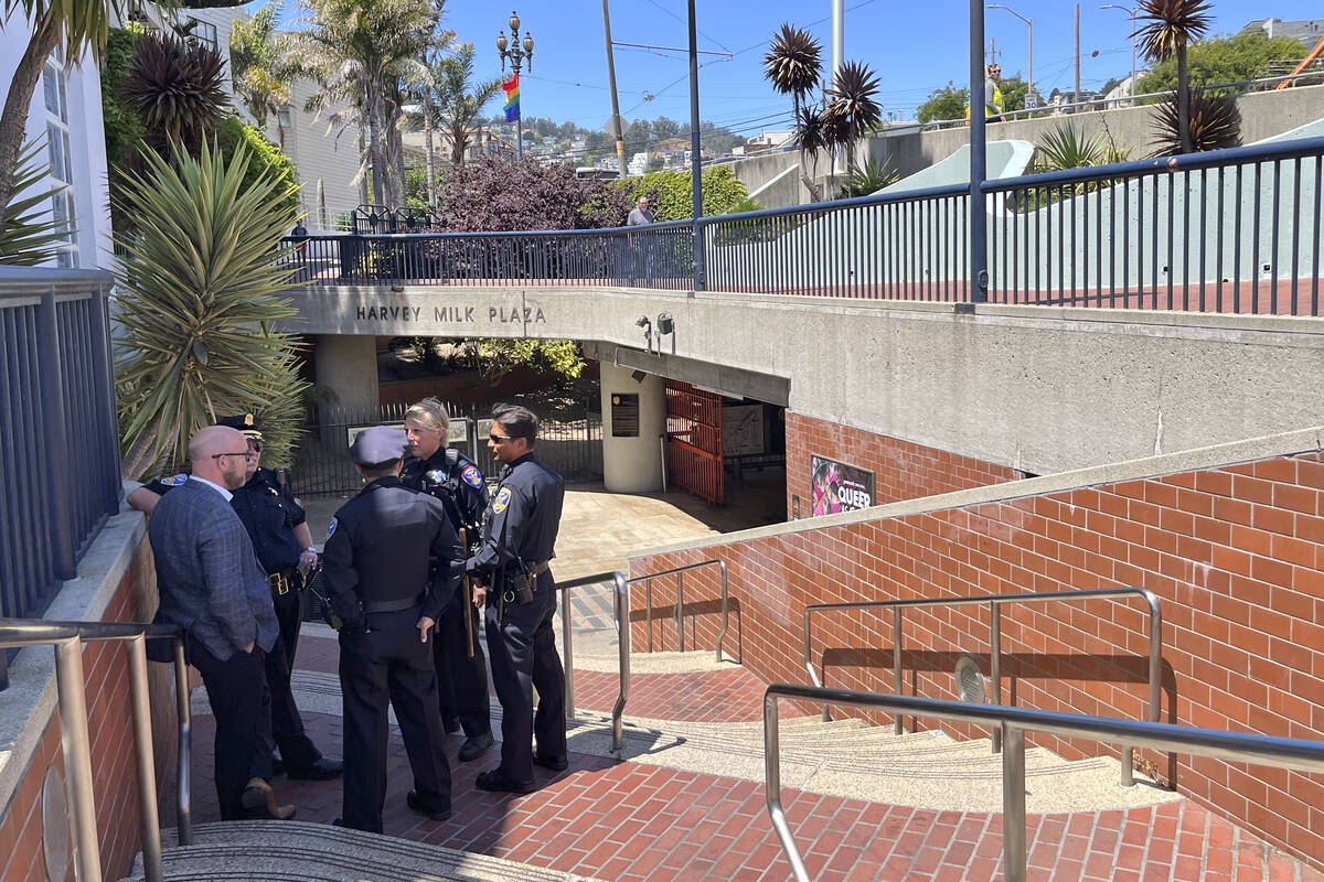 Police personnel confer outside the entrance to the Castro Muni Metro station following a shoot ...