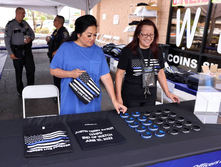 Minddie Lloyd, widow of late Las Vegas police Lt. Erik Lloyd, left, and Norma Rede place items ...