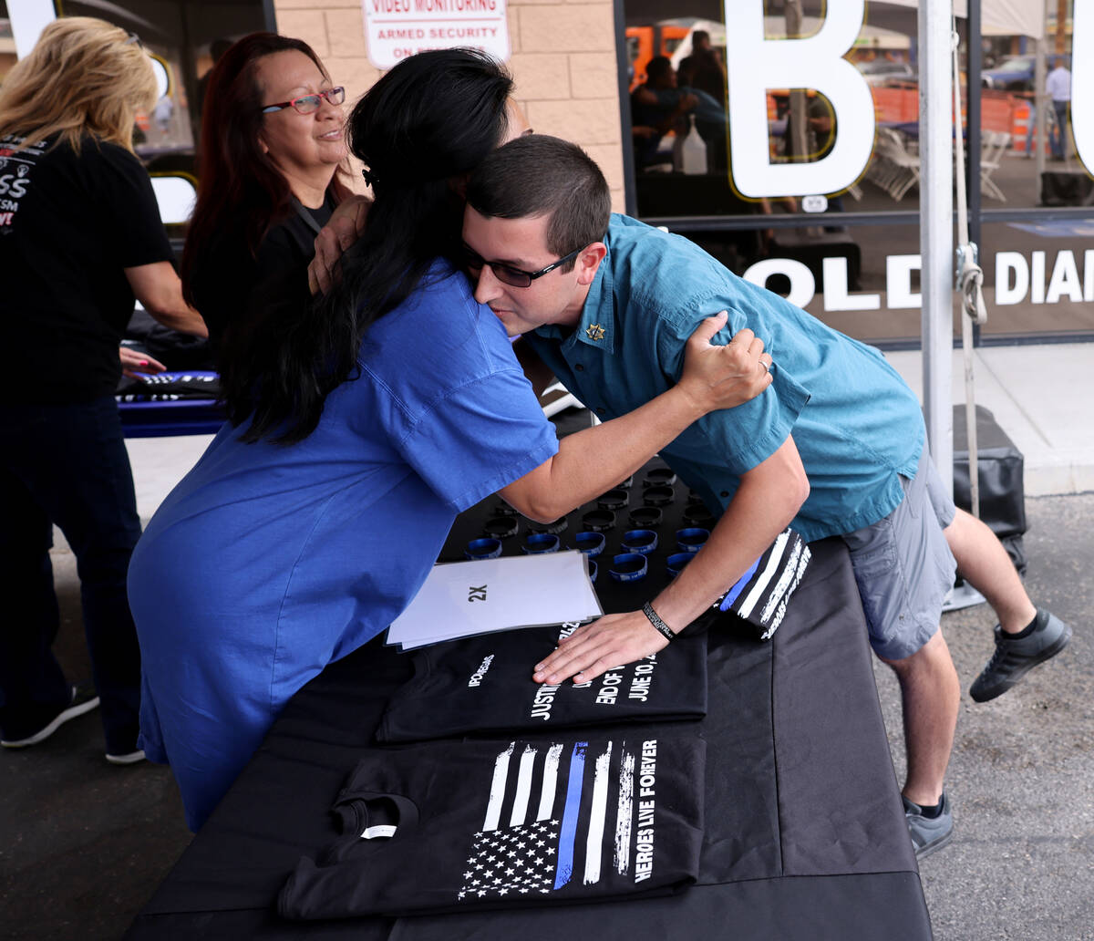 Minddie Lloyd, widow of late Las Vegas police Lt. Erik Lloyd, hugs Sean Terry, son of late Las ...