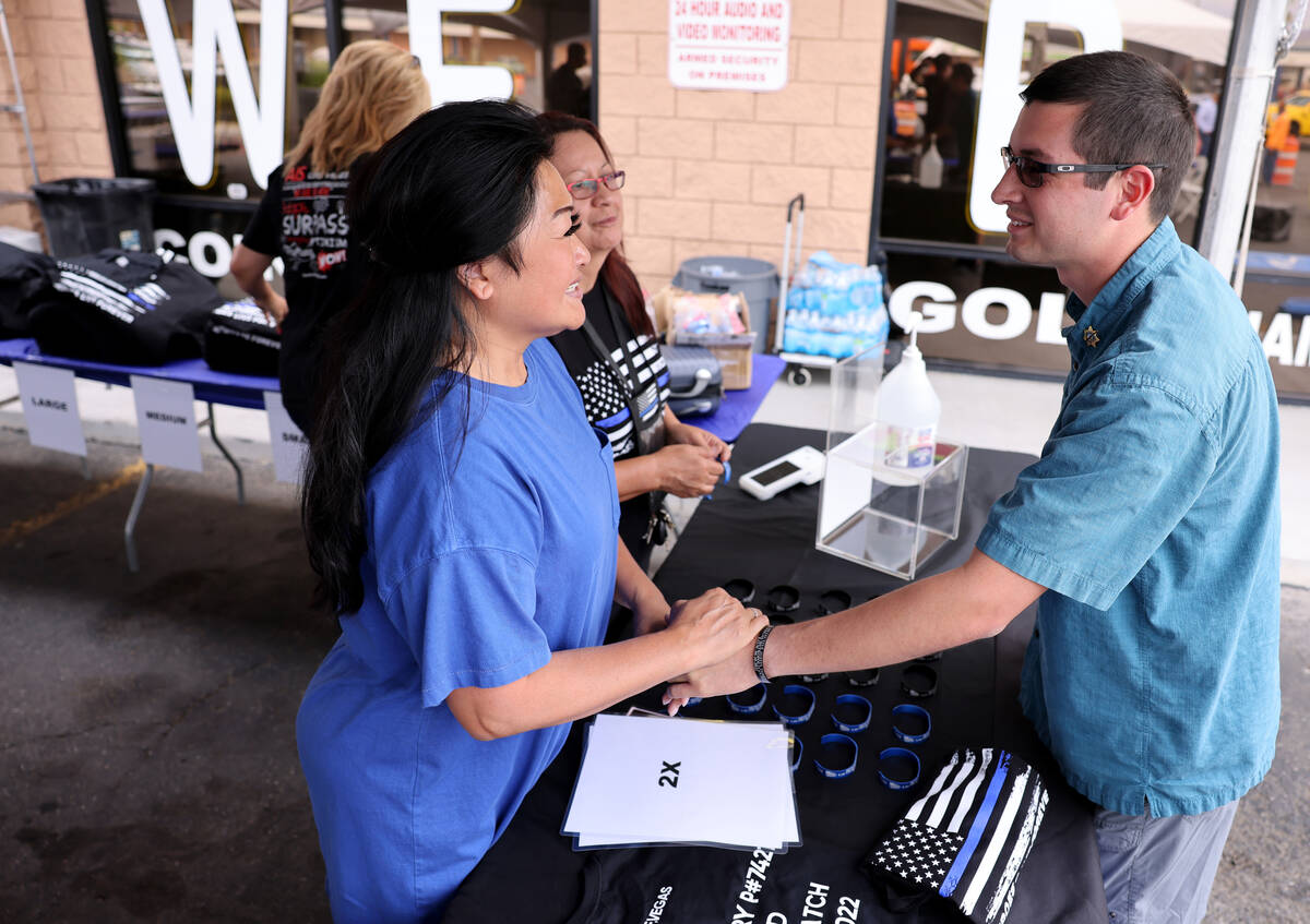 Minddie Lloyd, widow of late Las Vegas police Lt. Erik Lloyd, greets Sean Terry, son of late La ...