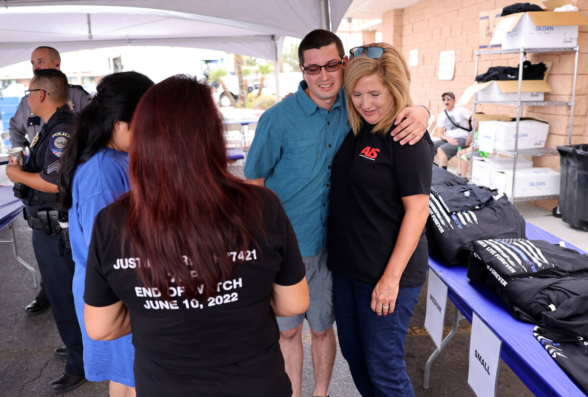 Sean Terry, son of late Las Vegas police Detective Justin Terry hugs volunteer Rhonda Hall duri ...