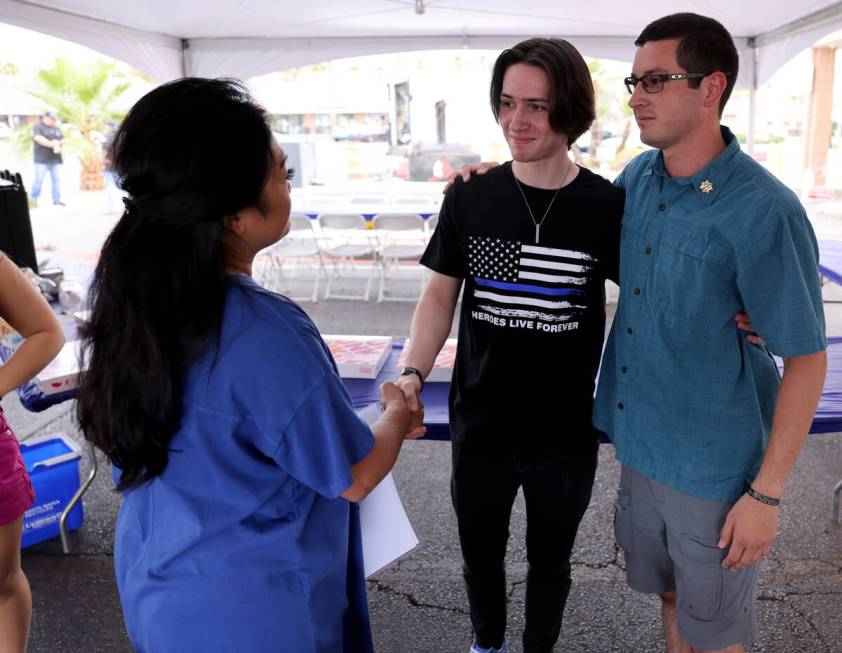 Minddie Lloyd, widow of late Las Vegas police Lt. Erik Lloyd, greets Sean Terry, right, and Jac ...