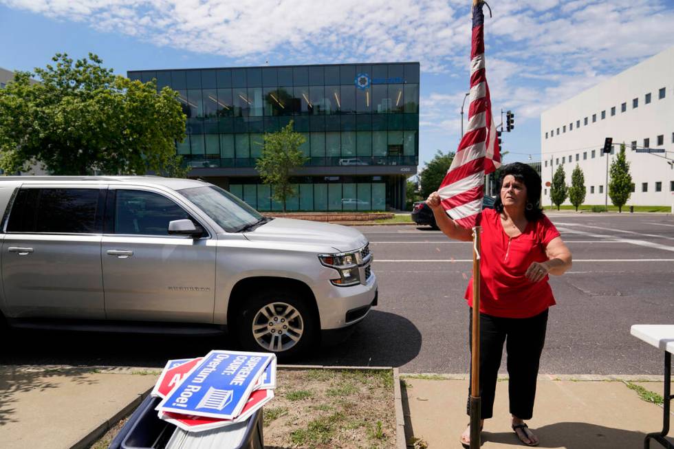 Defenders of the Unborn founder Mary Maschmeier, unfurls a U.S. flag outside Planned Parenthood ...