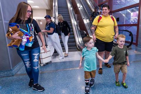 Watson Beas, 3 (center), walks with his brother Beckham, 5, as they all reunite with mom's Meag ...