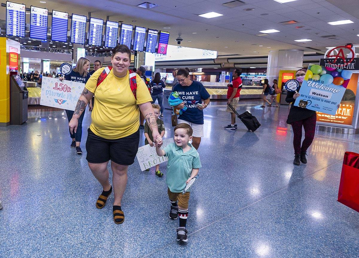 Jordyn Beas walks through the Terminal 1 baggage area with her son Watson, 3, having just arriv ...