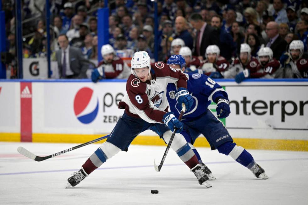 Colorado Avalanche defenseman Cale Makar (8) controls a puck in front of Tampa Bay Lightning le ...