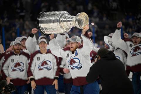 Colorado Avalanche center Nathan MacKinnon lifts the Stanley Cup after the team defeated the Ta ...