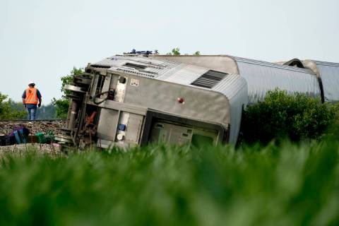 A worker inspects the scene of an Amtrak train which derailed after striking a dump truck, Mond ...