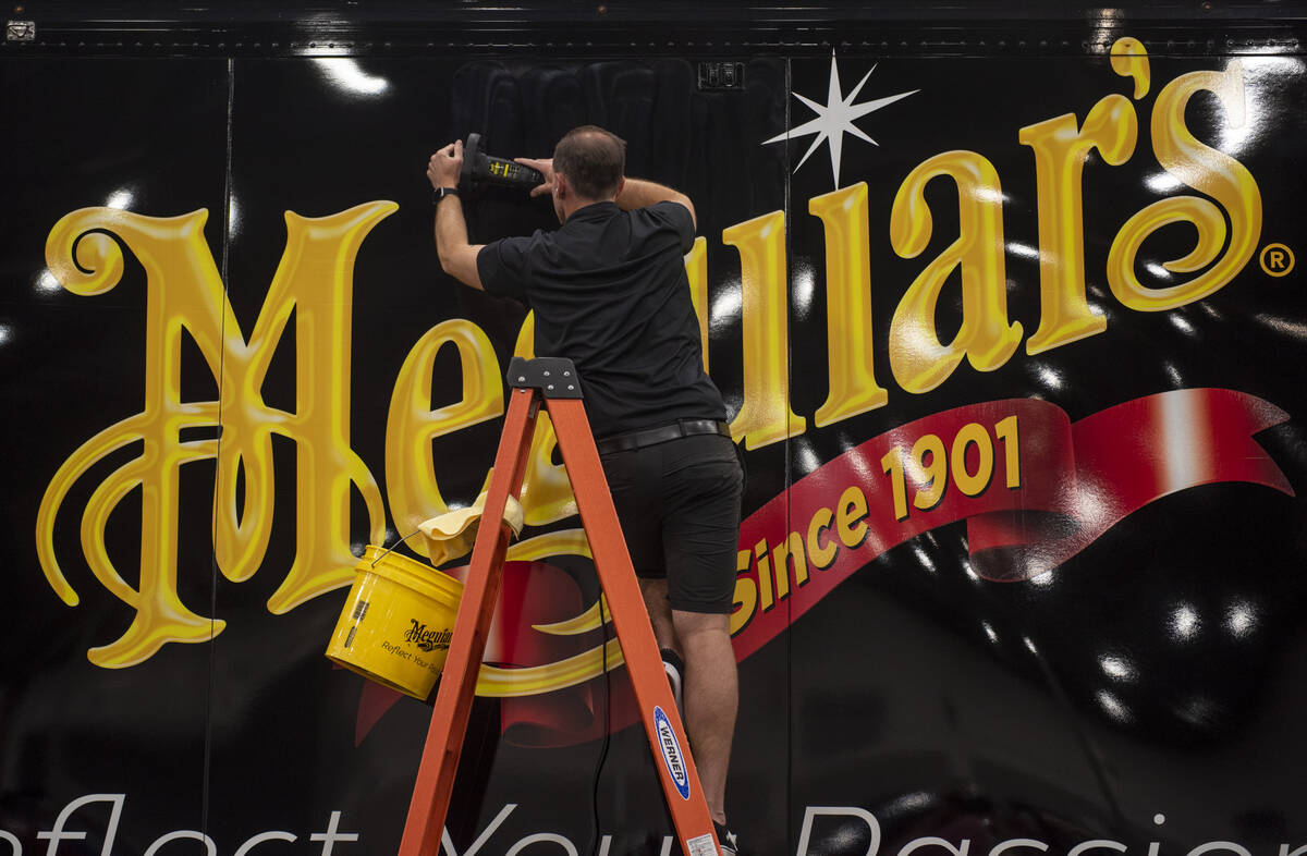 Justin Blank polishes the side of the Meguiar's trailer during the opening day of the Barrett-J ...