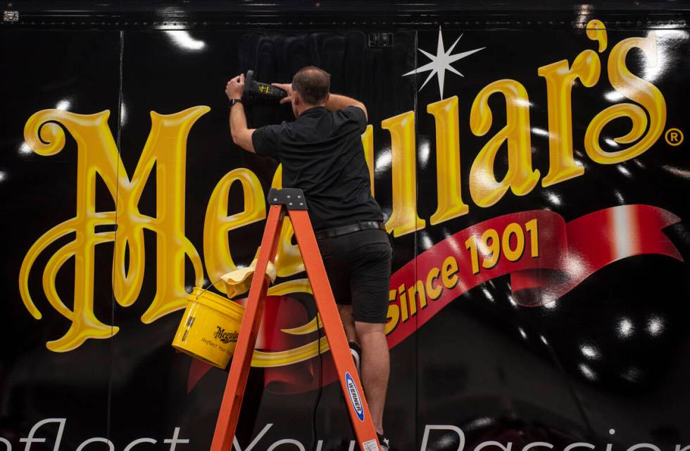 Justin Blank polishes the side of the Meguiar's trailer during the opening day of the Barrett-J ...