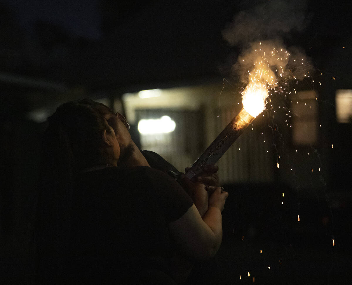 A couple shares a kiss as they light an illegal firework to celebrate Independence Day on Satur ...