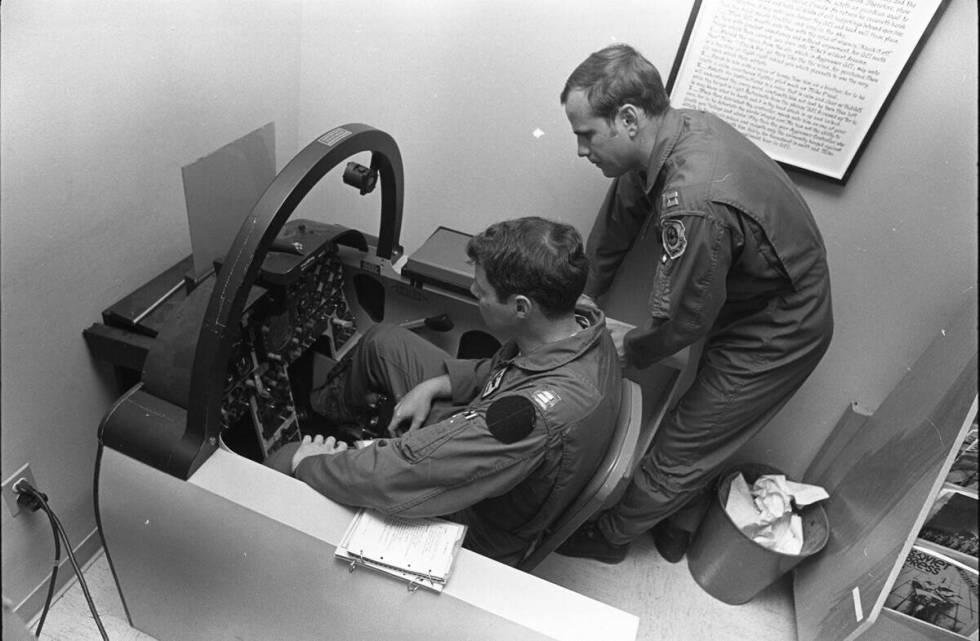Instructor Captain Scott Van Cleef teaches Captain “Tank” Payne in the pilot’s seat about ...