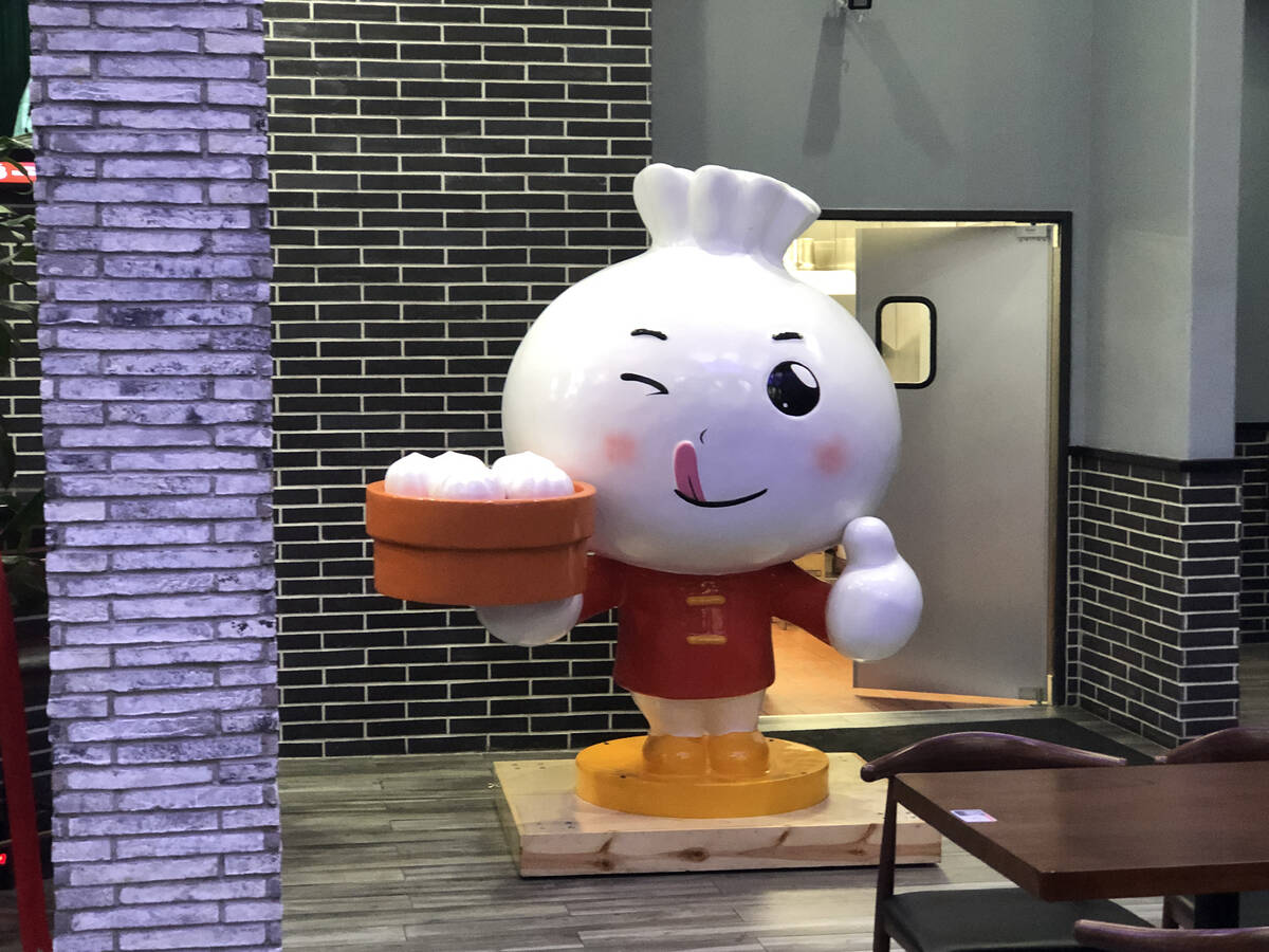 Chairman Bao, the mascot at Xiao Long Dumplings in the Chinatown Plaza, offers diners a steamer ...