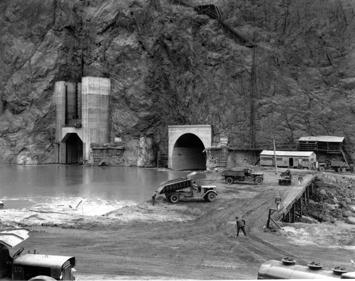 Construction of the Hoover Dam continues, a constant stream of large trucks dumping fifty tons ...