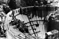 This aerial view shows a crest of the Hoover Dam, aka Boulder Dam, showing the highway leading ...