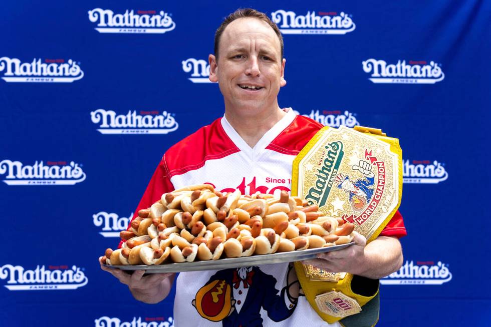 Competitive eater Joey Chestnut poses for photos with 76 hot dogs at a weigh-in before the Nath ...