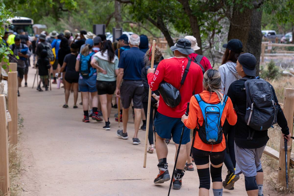 A long line forms to board the shuttle into Zion National Park on Memorial Day Weekend this yea ...