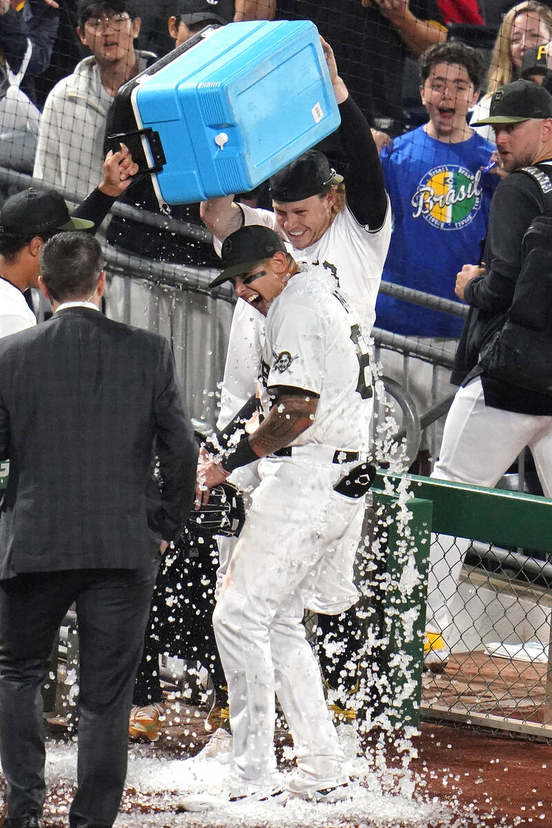 Pittsburgh Pirates' Bligh Madris, center, gets doused with a cooler of ice by teammates Jack Su ...