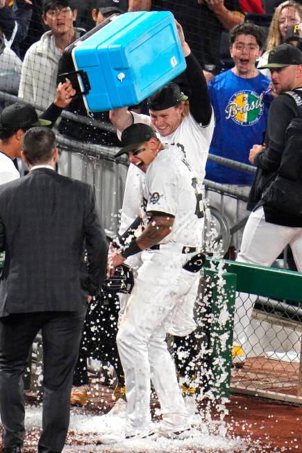 Pittsburgh Pirates' Bligh Madris, center, gets doused with a cooler of ice by teammates Jack Su ...