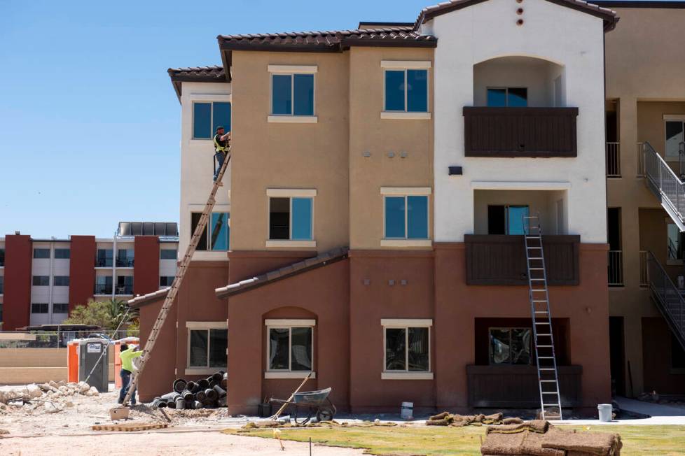 Workers put the finishing touches on a building at the Decatur Commons affordable housing compl ...