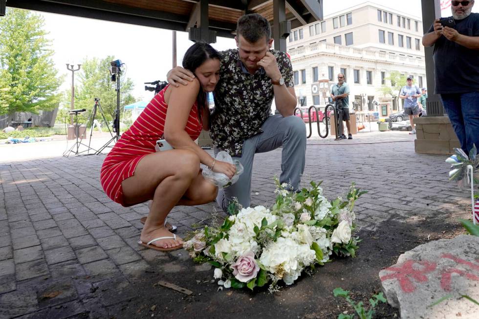 Brooke and Matt Strauss, who were married Sunday, pause after leaving their wedding bouquets in ...