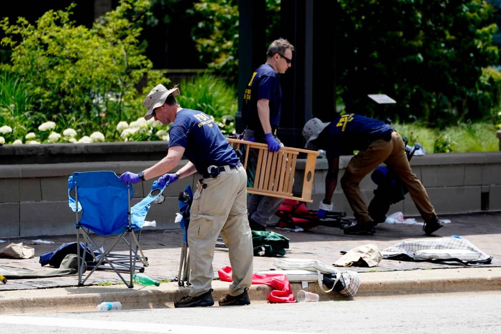 Members of the FBI's evidence response team remove personal belongings one day after a mass sho ...