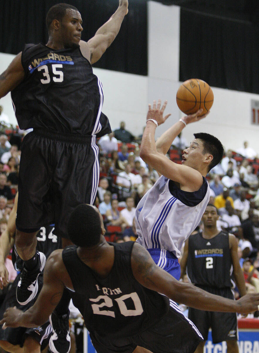 Dallas Mavericks basketball player Jeremy Lin attempts a shot against Washington Wizards player ...