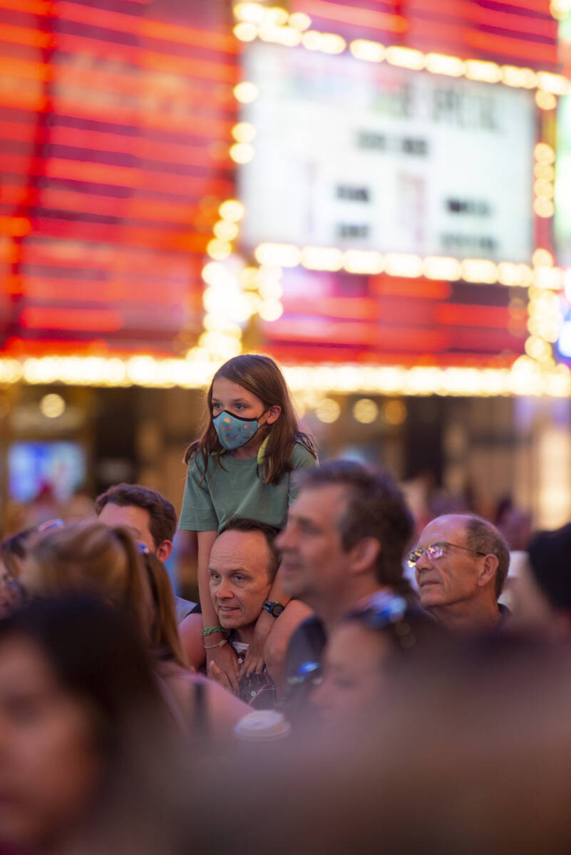 Bea Ray, 11, sits on the shoulders of Jay Ray as they watch street performers at the Fremont St ...