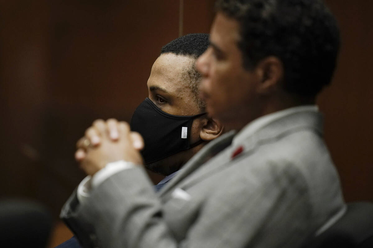 Eric Holder Jr., rear, who is accused of killing rapper Nipsey Hussle, sits in a courtroom with ...