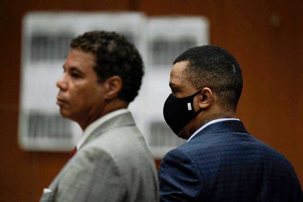 Eric Holder Jr., right, who is accused of killing rapper Nipsey Hussle, and his attorney, Aaron ...