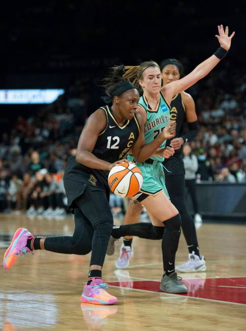 Las Vegas Aces guard Chelsea Gray (12) gets past New York Liberty's Sabrina Ionescu (20) during ...