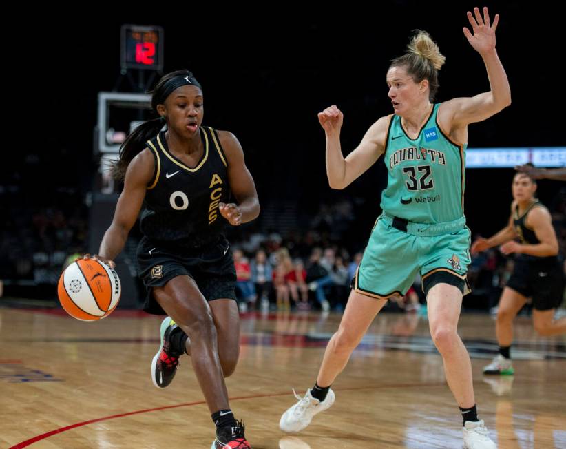 Las Vegas Aces guard Jackie Young (0) drives past New York Liberty's Sami Whitcomb (32) during ...