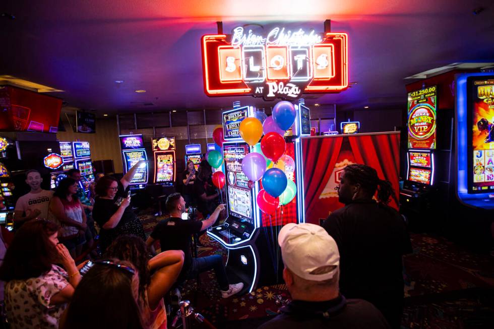 YouTuber Brian Christopher, center left, plays on his new slot machine Brian Christopher's Pop' ...