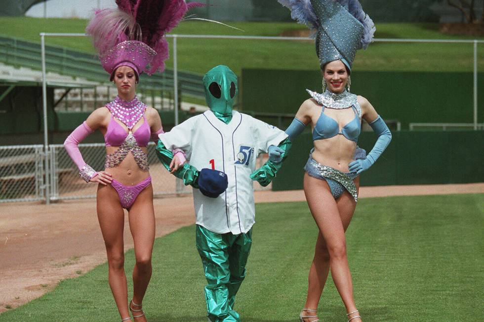 A mascot and two showgirls display the Las Vegas 51s' new uniforms at Cashman Field on Saturday ...