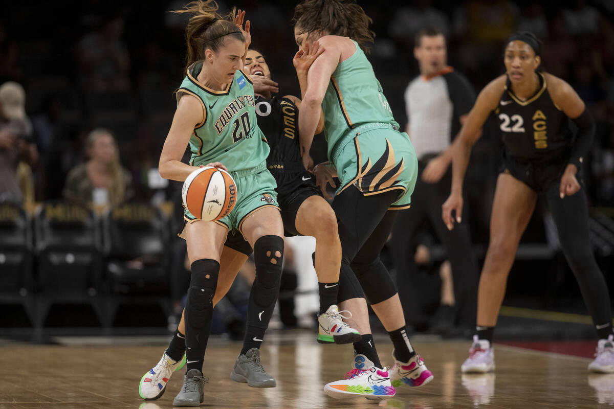 New York Liberty's Sabrina Ionescu (20) pushes past Las Vegas Aces guard Kelsey Plum (10) durin ...