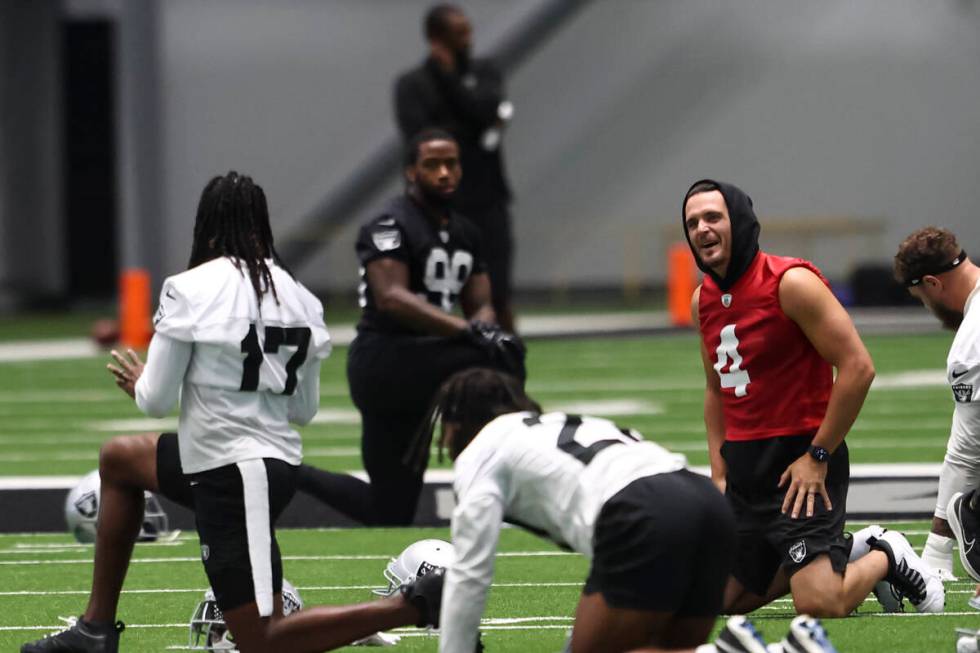 Raiders quarterback Derek Carr, right, shares a laugh with wide receiver Davante Adams (17) as ...