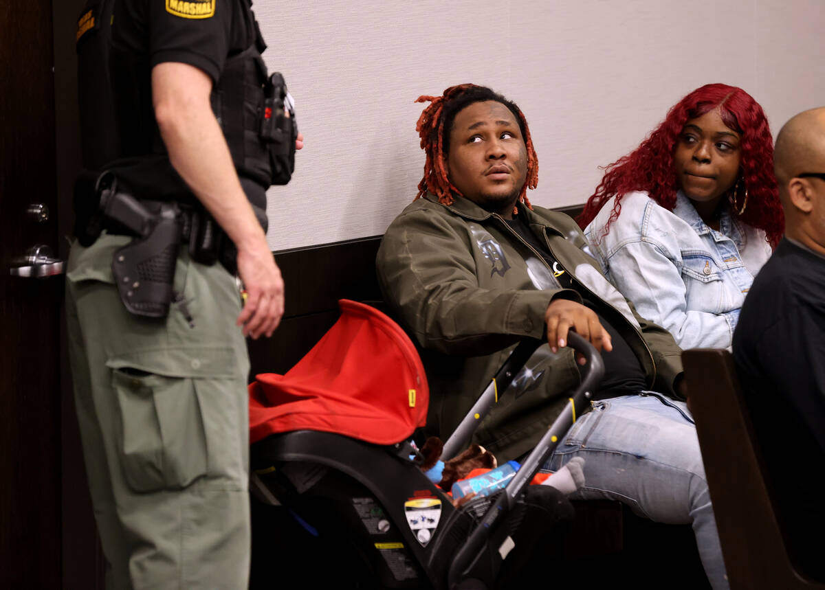 Keshawn Meyi, 25, waits for his traffic ticket hearing with Angel Wallace, 20, and their child, ...