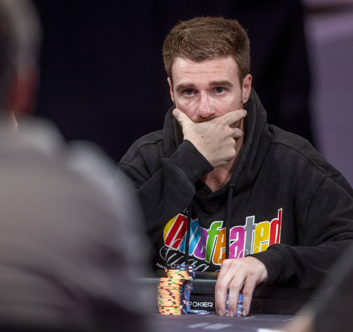 Player Adrian Attenborough considers his hand during final table play at the WSOP Main Event wi ...