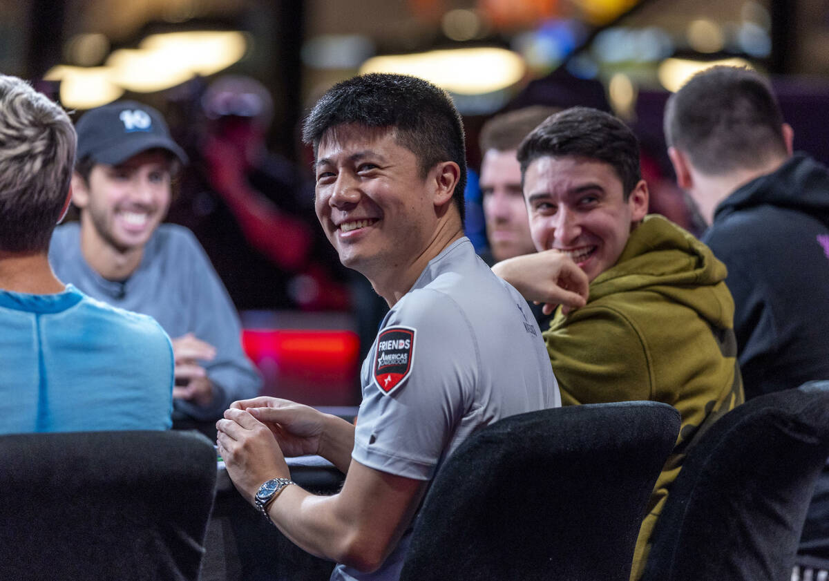 Players Matthew Su, left, and Michael Duek laugh as the crowd chants during final table play at ...