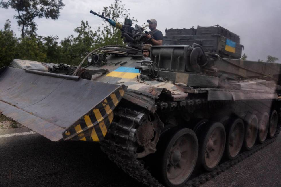 FILE - Ukrainian soldiers ride a tank on a road, in Stupochky, Donetsk region, eastern Ukraine, ...