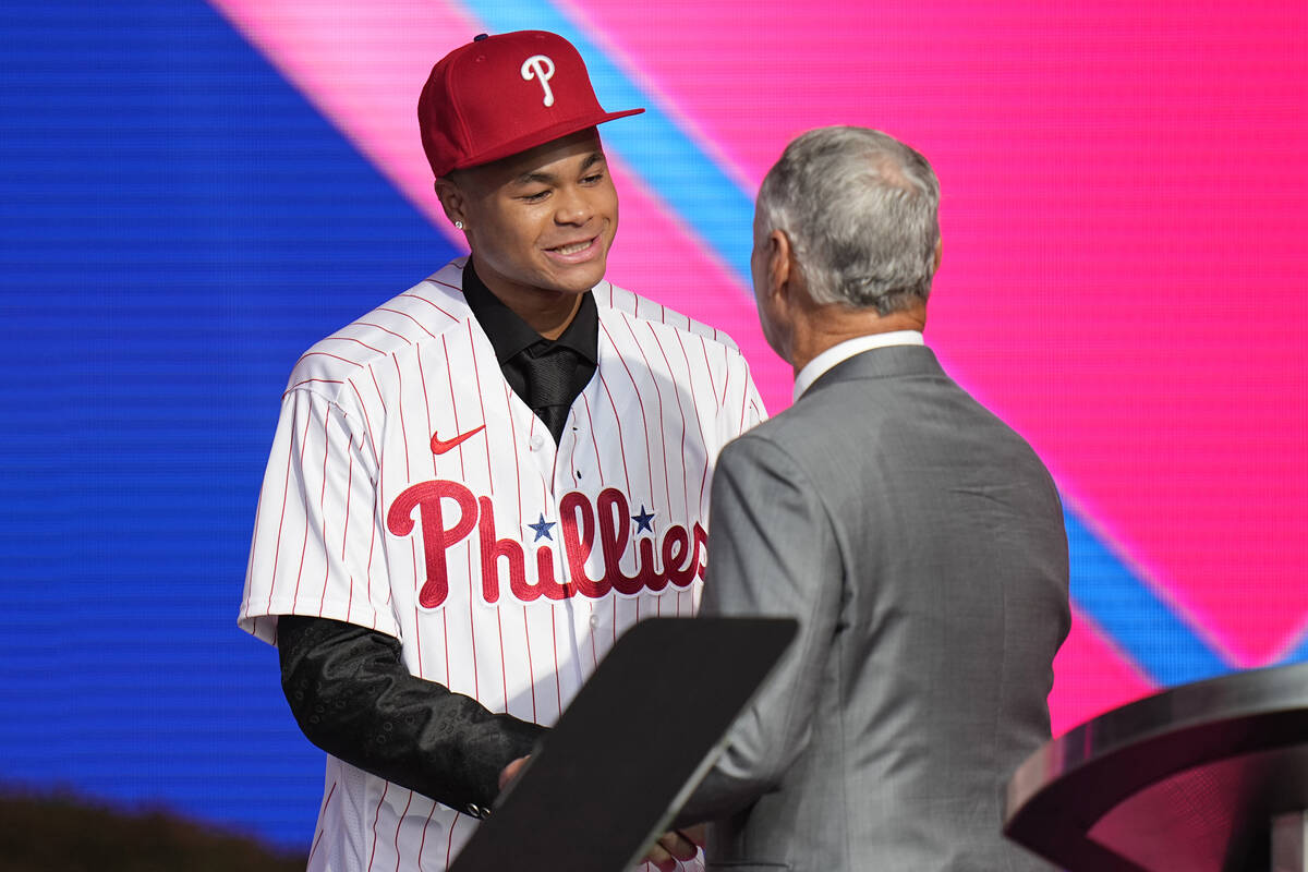 Justin Crawford, left, shakes hands with MLB Commissioner Rob Manfred after being selected by t ...