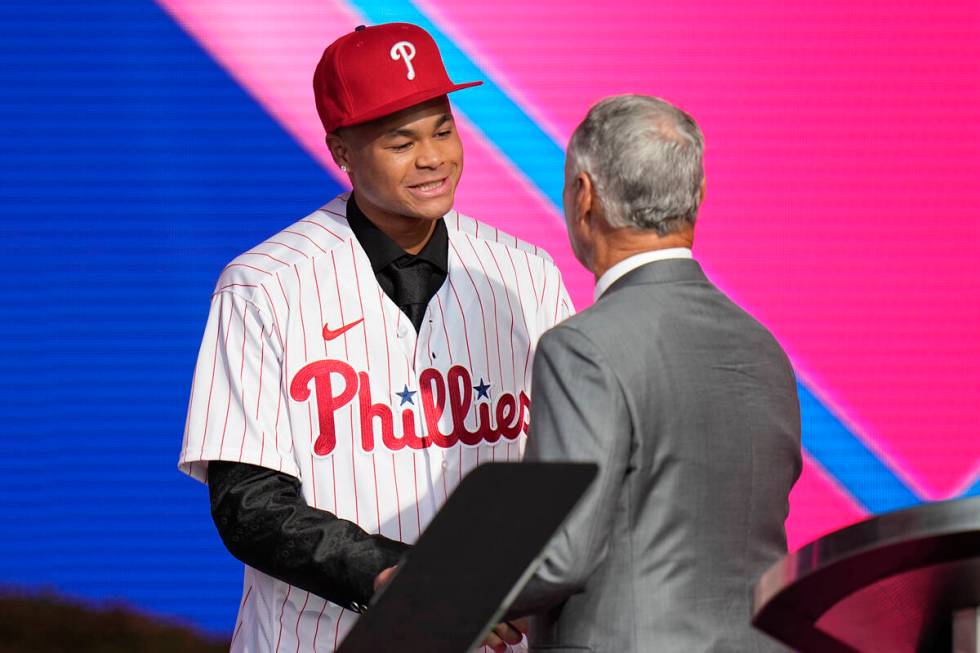 Justin Crawford, left, shakes hands with MLB Commissioner Rob Manfred after being selected by t ...